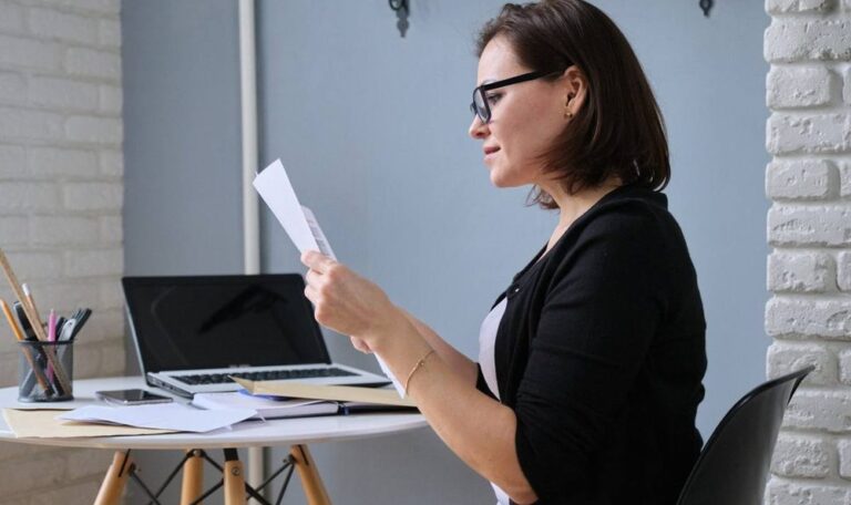Business owner reading forwarded mail from the best virtual address for business at her desk