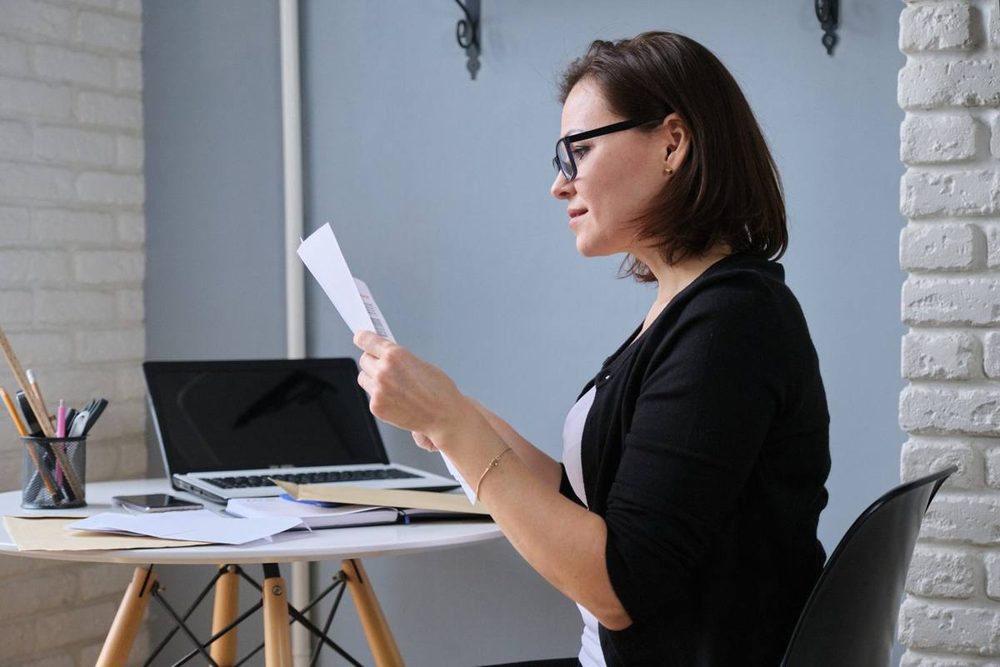 Business owner reading forwarded mail from the best virtual address for business at her desk